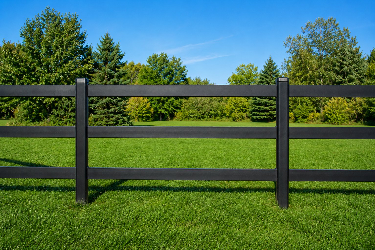 Black 3-rail Kuptz steel fence on a green pasture